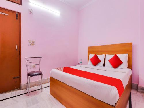 Hotel Yug Residency في حاريدوار: غرفة نوم بسرير كبير وكرسي