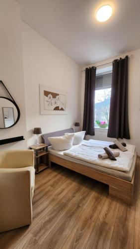 a bedroom with a bed and a chair and a window at ELENA flat Orchidee Duisburg Zentrum in Duisburg