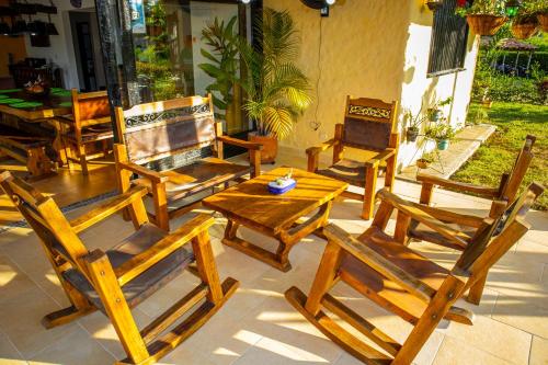 a group of wooden chairs and tables on a patio at Villas Panaca Portal 1 in Quimbaya