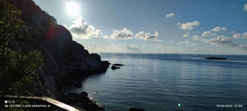 a group of people sitting on the side of a cliff at Lighthouse Bungalows in Haad Rin