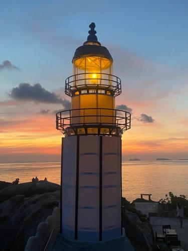 a lighthouse with a light on top of it at Lighthouse Bungalows in Haad Rin