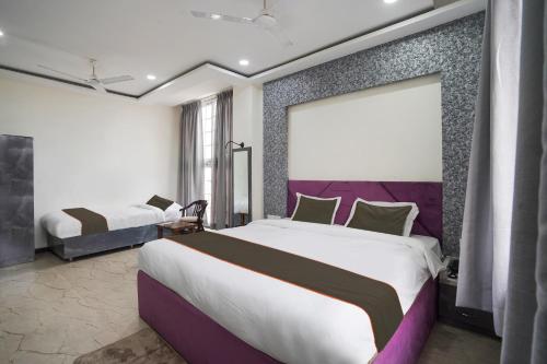 1 Schlafzimmer mit 2 Betten und einem großen Fenster in der Unterkunft Hotel City Pride in Raipur