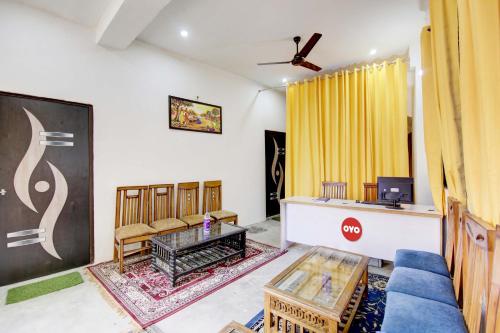 a living room with a blue couch and a yellow curtain at Super OYO Flagship Blossom Inn Burari in New Delhi