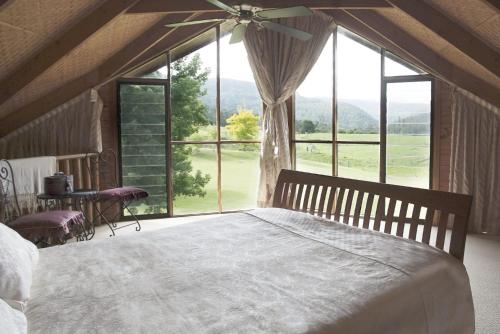 a bedroom with a large bed and a large window at Cloud Nine Chalet Luxury retreat in Upper River in Upper Kangaroo River