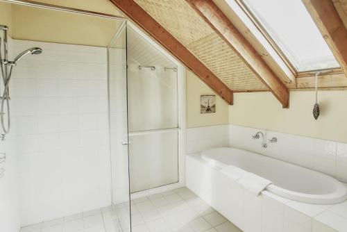 a bathroom with a tub and a glass shower at Cloud Nine Chalet Luxury retreat in Upper River in Upper Kangaroo River