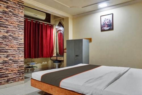 1 dormitorio con 1 cama grande y cortinas rojas en Collection O Hotel Shiv Inn en Pune
