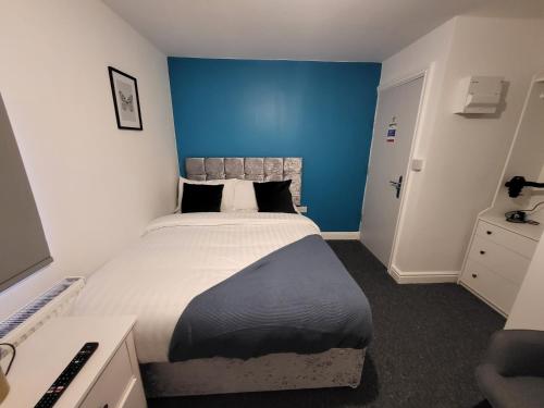 a bedroom with a large bed with a blue wall at Stay Sleep Rest - Tring Vale in Nottingham