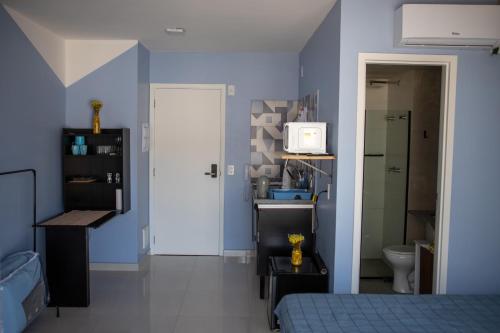 a bedroom with blue walls and a bed and a bathroom at Blue Liberdade in São Paulo