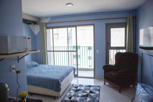 une chambre avec un lit et une chaise et un balcon dans l'établissement Blue Liberdade, à São Paulo