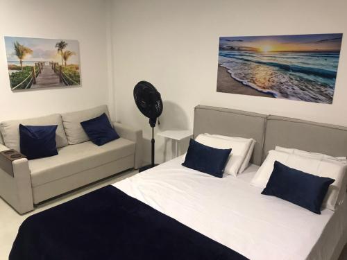 1 dormitorio con 1 cama, 1 sofá y 1 pintura en Studio Praia dos Carneiros Tamandare en Tamandaré