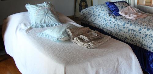 un letto bianco con cuscini bianchi e blu di VILLA ADRY Mon Reve Holidays ad Aosta