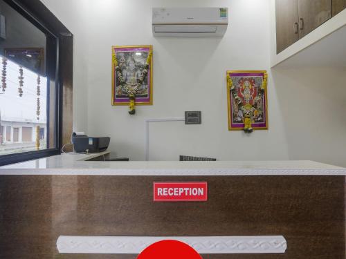 a reception counter with a red sign on the wall at OYO Flagship Hotel Rahul Service Appartment 2 in Nagpur