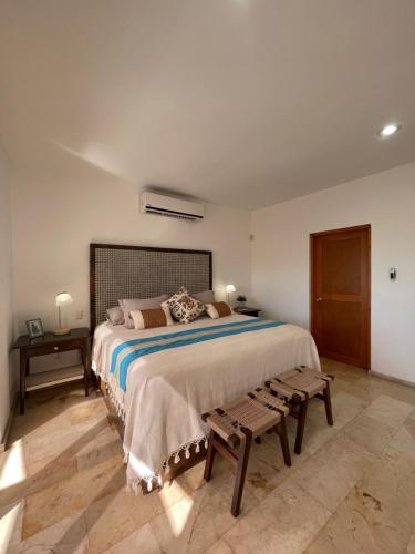 a bedroom with a large bed and a bench at Sea view, king-size bed, wheelchair access in Cabo San Lucas