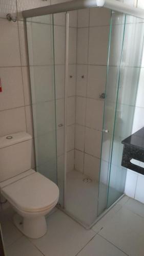 a bathroom with a toilet and a glass shower at O Canto do Mar - Pontal do Coruripe in Coruripe