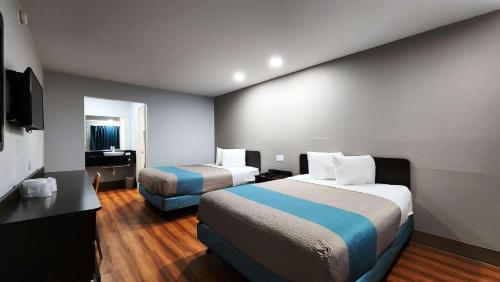 Habitación de hotel con 2 camas y escritorio en Motel 6-Webster, TX - Houston - Nasa Lake, en Webster