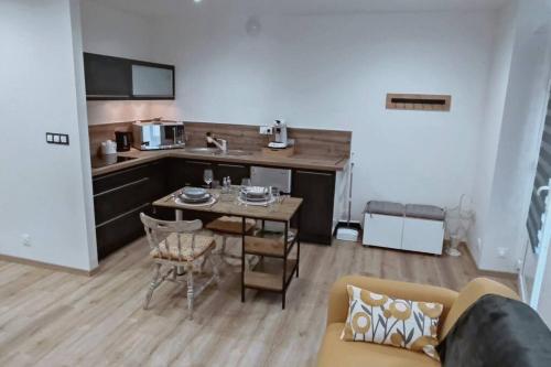 a living room with a table and a kitchen at Tout confort. Appartement 2 pers. centre-ville in Le Creusot