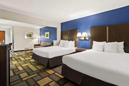 a hotel room with two beds and a couch at Best Western Galleria Inn & Suites in Houston