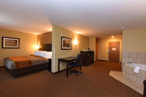 ジラにあるBest Western Plus Vintage Valley Innのベッド、デスク、バスタブが備わるホテルルームです。