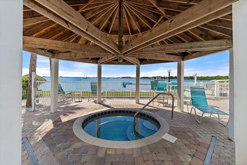 a patio with a hot tub under a wooden roof at Sea Escape - Condo with Pool Hot Tub Plus Private Community Beach in St. Petersburg