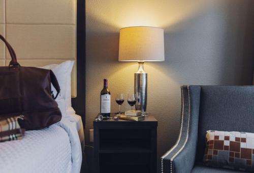 a hotel room with a bed with a lamp and wine glasses at CopperLeaf Boutique Hotel & Spa; BW Premier Collection in Appleton