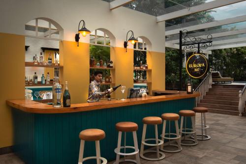 a man standing at a bar in a restaurant at Radisson Blu Bengaluru Outer Ring Road in Bengaluru