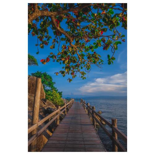 a wooden bridge over the ocean at Lighthouse Bungalows in Haad Rin