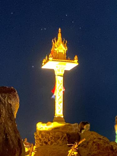 a lit up tower on top of a mountain at night at Lighthouse Bungalows in Haad Rin
