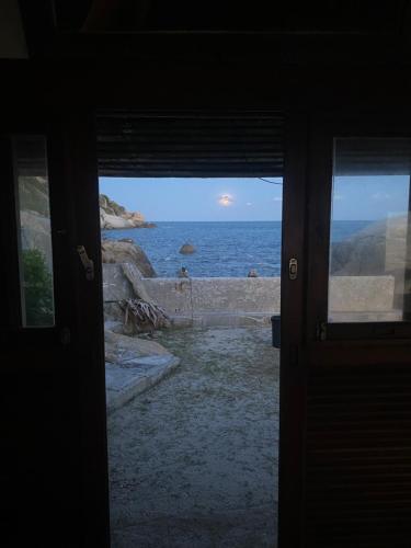 an open door with a view of the ocean at Lighthouse Bungalows in Haad Rin