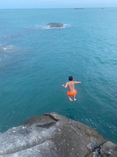a man in the water in the ocean at Lighthouse Bungalows in Haad Rin