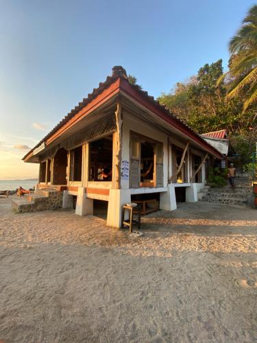 a building on the beach with the ocean in the background at Lighthouse Bungalows in Haad Rin