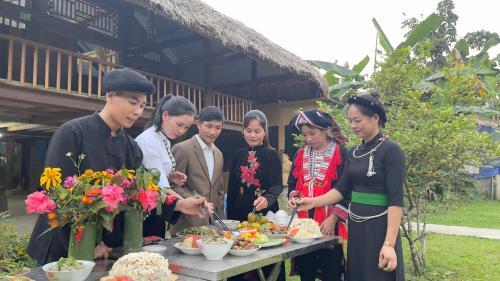 a group of people standing around a table with food at Ngoặng homestay - phòng nghỉ trọ in Chiêm Hóa