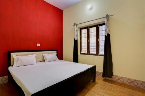 a bedroom with a bed with red walls and a window at HOTEL SS PARADISE in Lucknow