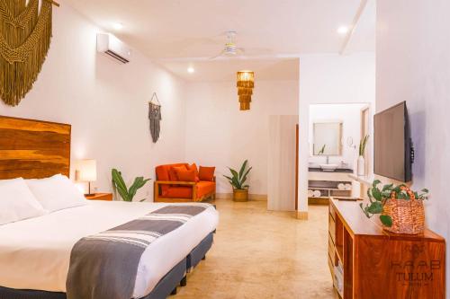 a bedroom with a bed and a living room at Kaab Tulum in Tulum