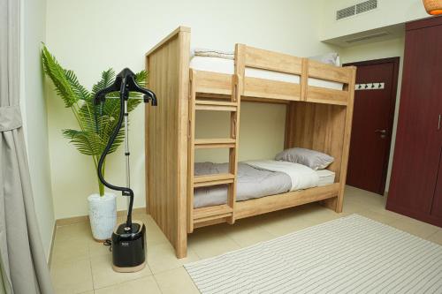 ein Etagenbett aus Holz mit einer Topfpflanze in einem Zimmer in der Unterkunft Pure Sand - Luxury Hostel JBR Dubai in Dubai