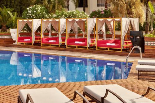 a pool with chaise lounge chairs next to a pool at Fes Marriott Hotel Jnan Palace in Fès