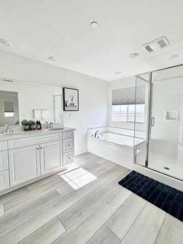 a white bathroom with a tub and a shower at NEW Luxurious 5BR/3BATHES Home, Spacious and Retreat location with Modern Amenities in Ontario