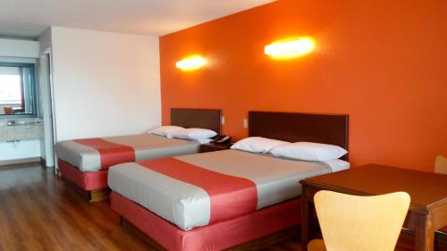a hotel room with two beds and a table at Motel 6-Covington, TN in Covington