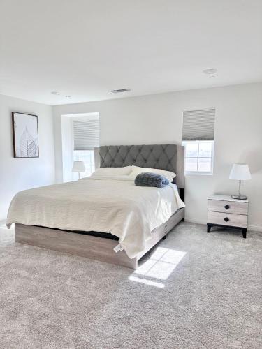 1 dormitorio blanco con 1 cama grande y mesita de noche en NEW Luxurious 5BR/3BATHES Home, Spacious and Retreat location with Modern Amenities en Ontario