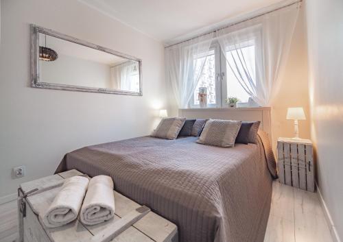 Bianco Apartament في غدينيا: غرفة نوم مع سرير ومرآة على الحائط