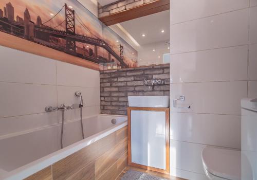 Bianco Apartament في غدينيا: حمام مع حوض ومرحاض ومغسلة