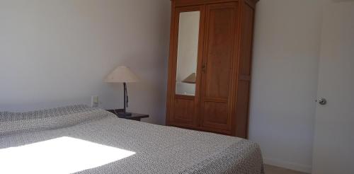 a bedroom with a bed and a lamp and a mirror at Petrel in La Paloma