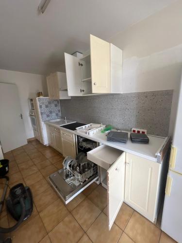 une cuisine avec des armoires blanches et un comptoir dans l'établissement Cholet - Lorraine, à 25min du Puy du Fou, à Cholet