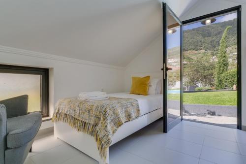 a bedroom with a bed and a chair at Passion Villa in Machico