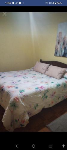- une chambre avec un lit fleuri dans l'établissement Cabañas y Hospedaje Claudia, à Temuco