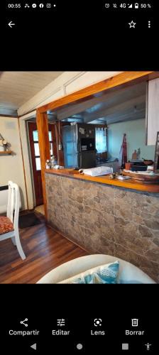 une photo d'une cuisine avec un mur en pierre dans l'établissement Cabañas y Hospedaje Claudia, à Temuco