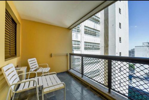 uma varanda com cadeiras e vista para um edifício em Apart hotel - apartments em Campinas