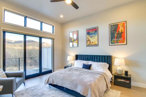 a bedroom with a bed and a chair and windows at Modern Bozeman Escape with Bridger Mountain Views! in Bozeman
