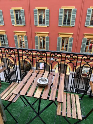 a wooden bench sitting on top of a balcony at NICEHOME MASSENA in Nice