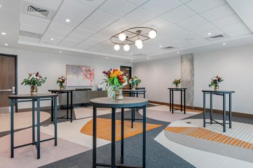 a room with three tables with flowers on them at Cambria Hotel Austin Downtown in Austin
