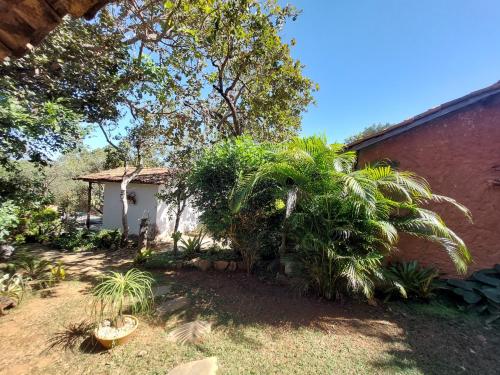 ein Haus mit einer Palme neben einem Gebäude in der Unterkunft Pousada Bangalôs Cipó in Serra do Cipo